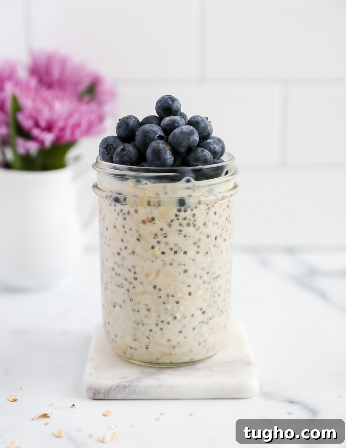 Side shot of oats in a jar topped with blueberries