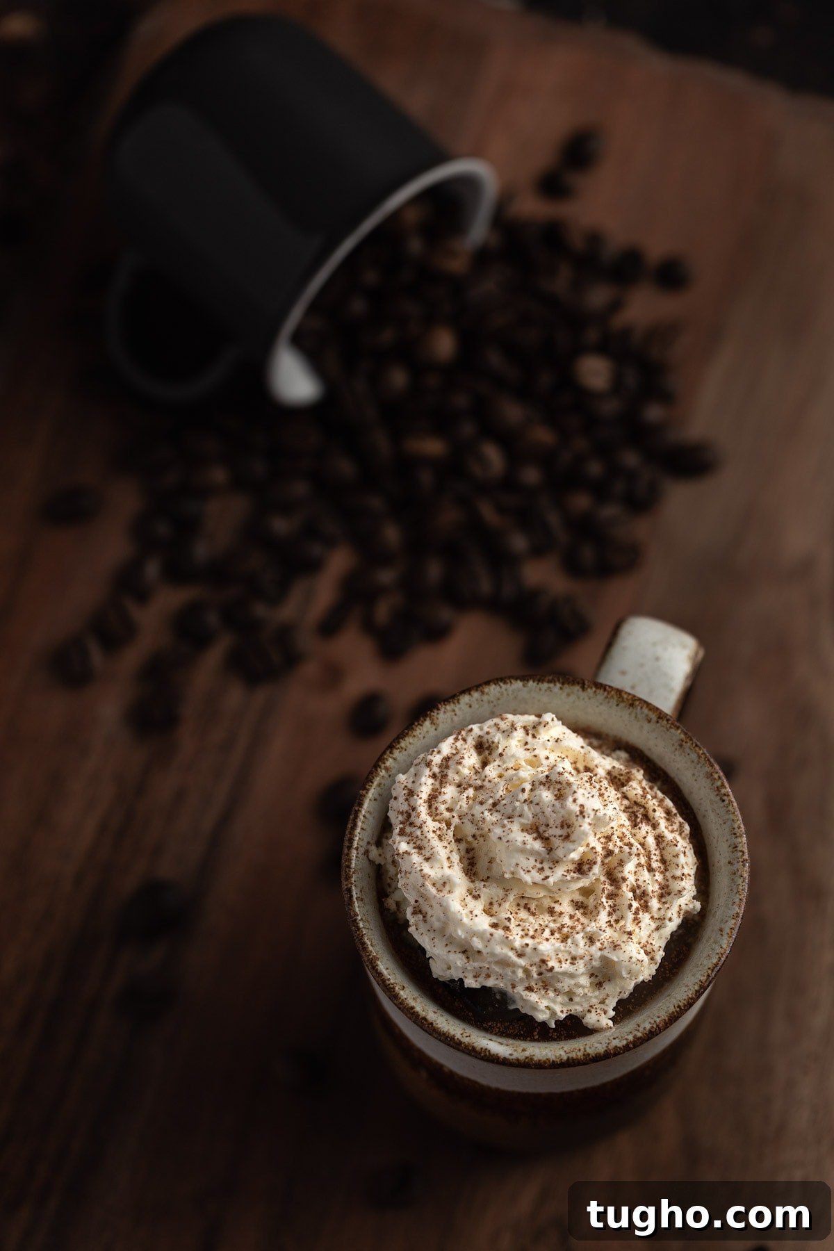 Baileys Iced Coffee Recipe 6 Overhead view of iced coffee topped with whipped cream on a wooden table.