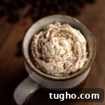 Overhead view of Baileys iced coffee topped with whipped cream and a sprinkle of cocoa powder.