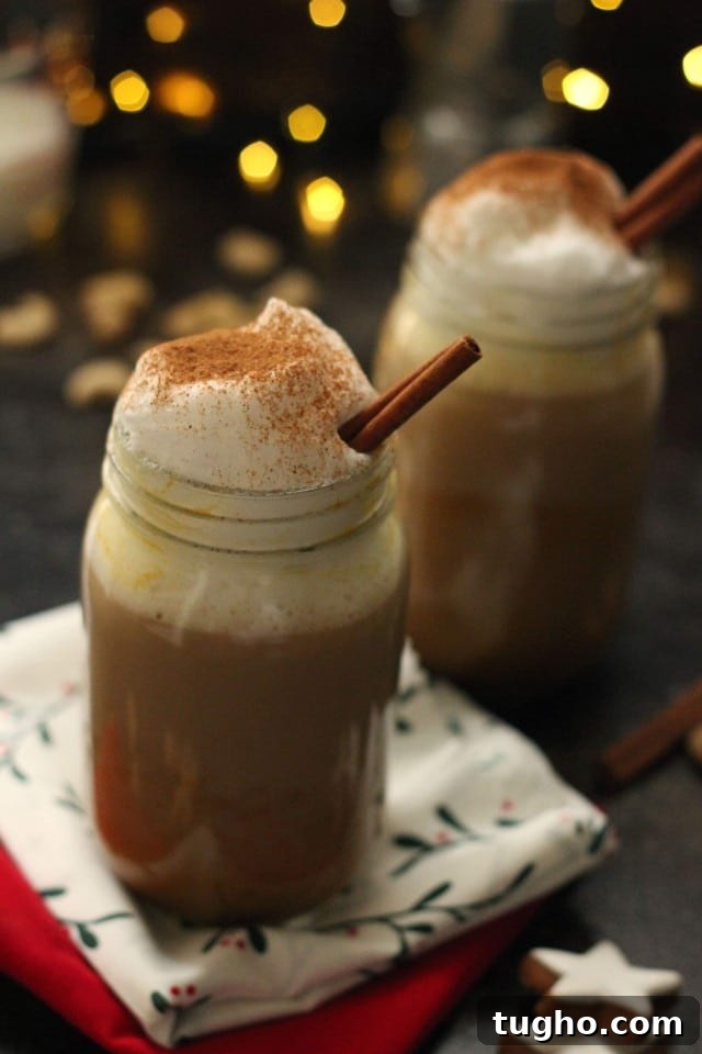 Creamy Vegan Pumpkin Spice Latte Recipe 10 Healthy Vegan Pumpkin Spice Latte in a Mason Jar Topped with Cashew Whipped Milk in a Christmas Setup with Lights in the Background