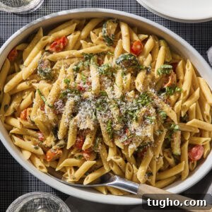 Pan with creamy pasta made with zucchini and burst cherry tomatoes.