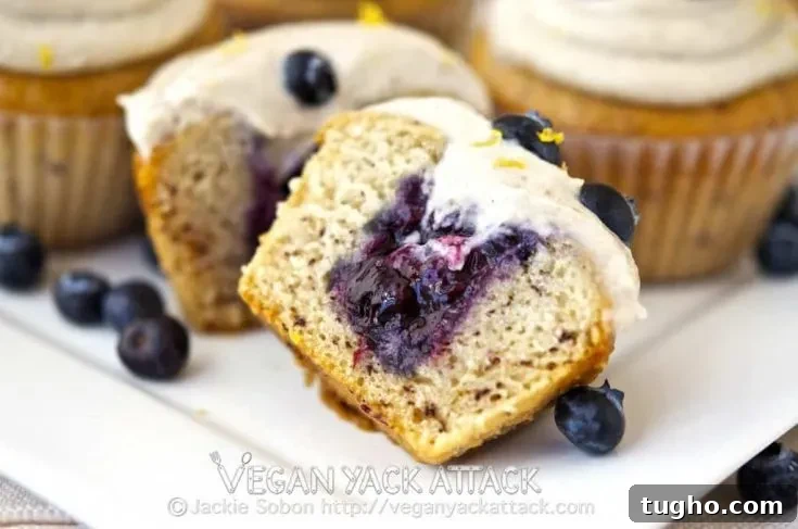 Cut cupcake showing berry filling and frosting