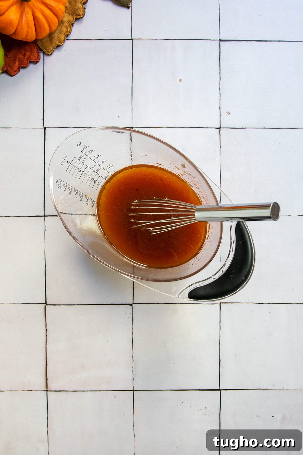 Pumpkin Granola Recipe with Maple or Date Syrup 5 Wet ingredients in a measuring cup with a whisk.