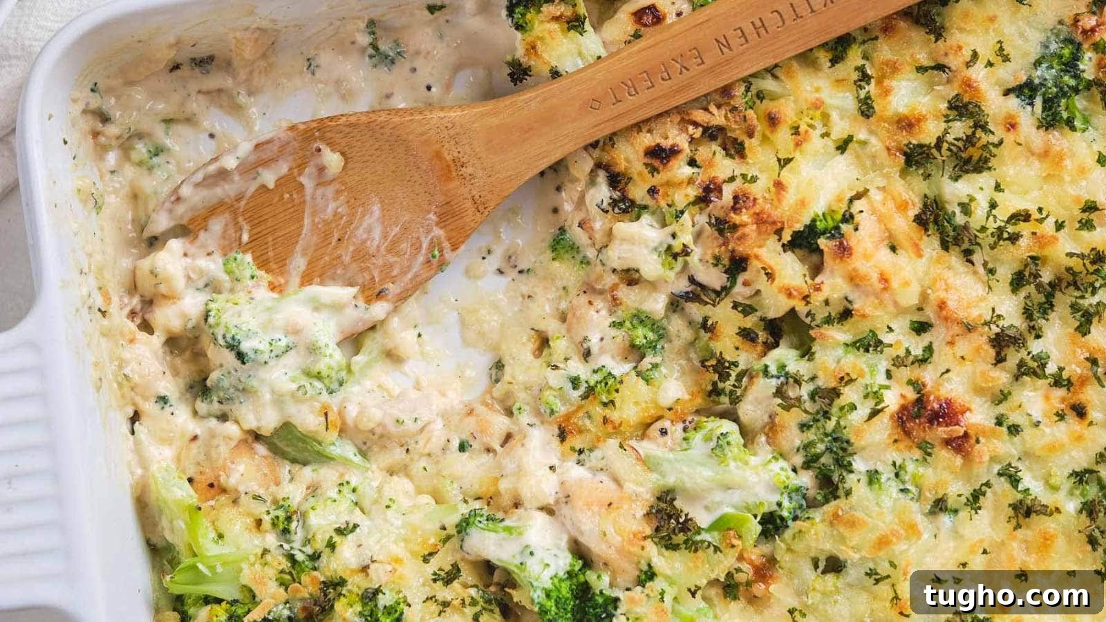 17 No-Fuss Dinners That Make the Whole Family Smile 15 A wooden spoon scooping chicken broccoli alfredo casserole out of a serving dish.