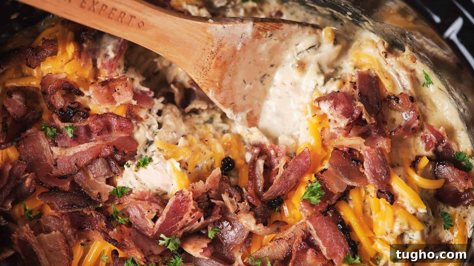 17 No-Fuss Dinners That Make the Whole Family Smile 7 A close-up of slow-cooker-crack-chicken being stirred with a wooden spoon.