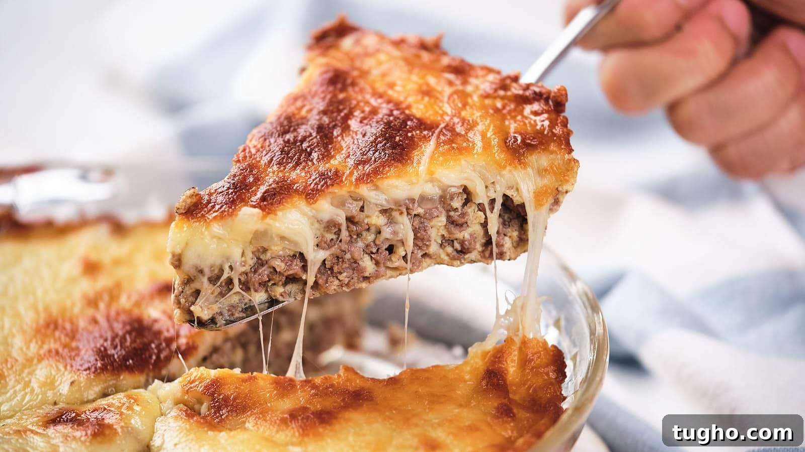 17 No-Fuss Dinners That Make the Whole Family Smile 10 A slice of cheeseburger pie being lifted, showing layers of meat and melted cheese.