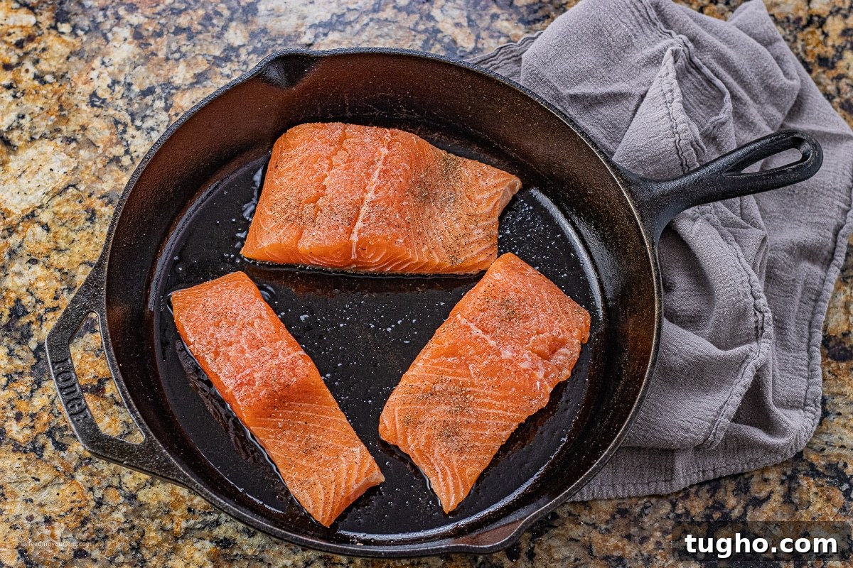 salmon cooking in a cast iron skillet