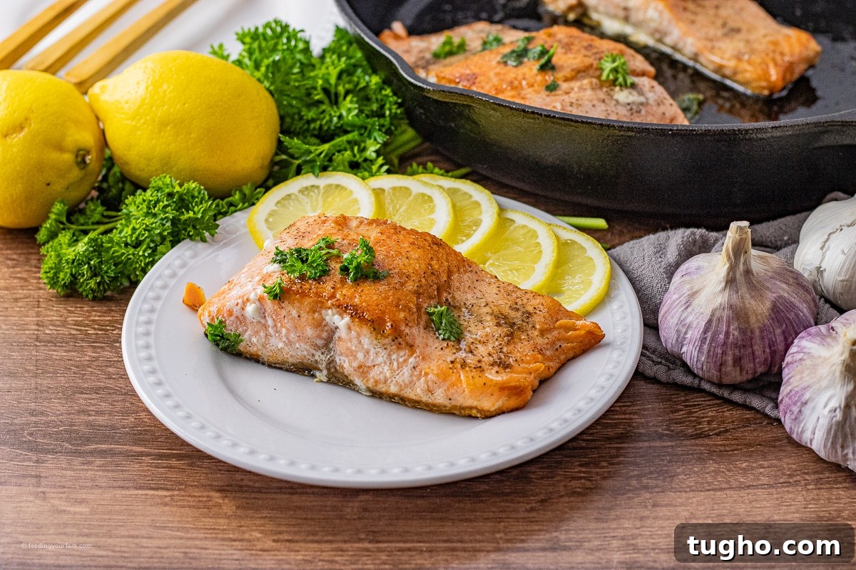 salmon filet on a white circle plate with lemon slices