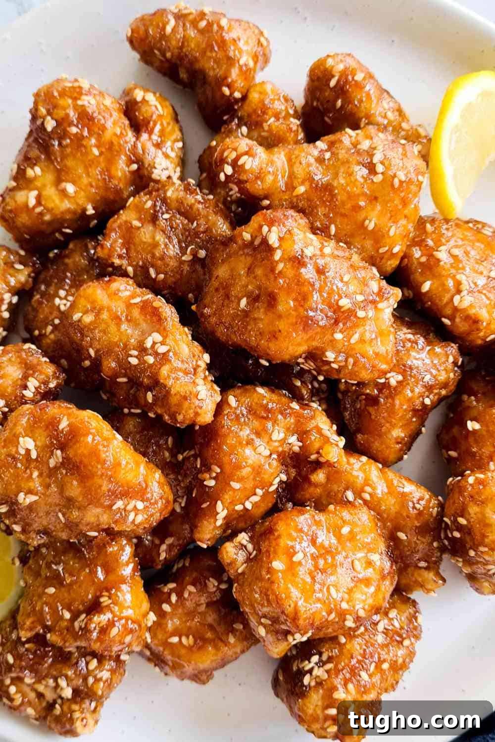 Homemade Crispy Honey Sesame Chicken Recipe 3 Crispy honey glazed chicken bites on a white plate