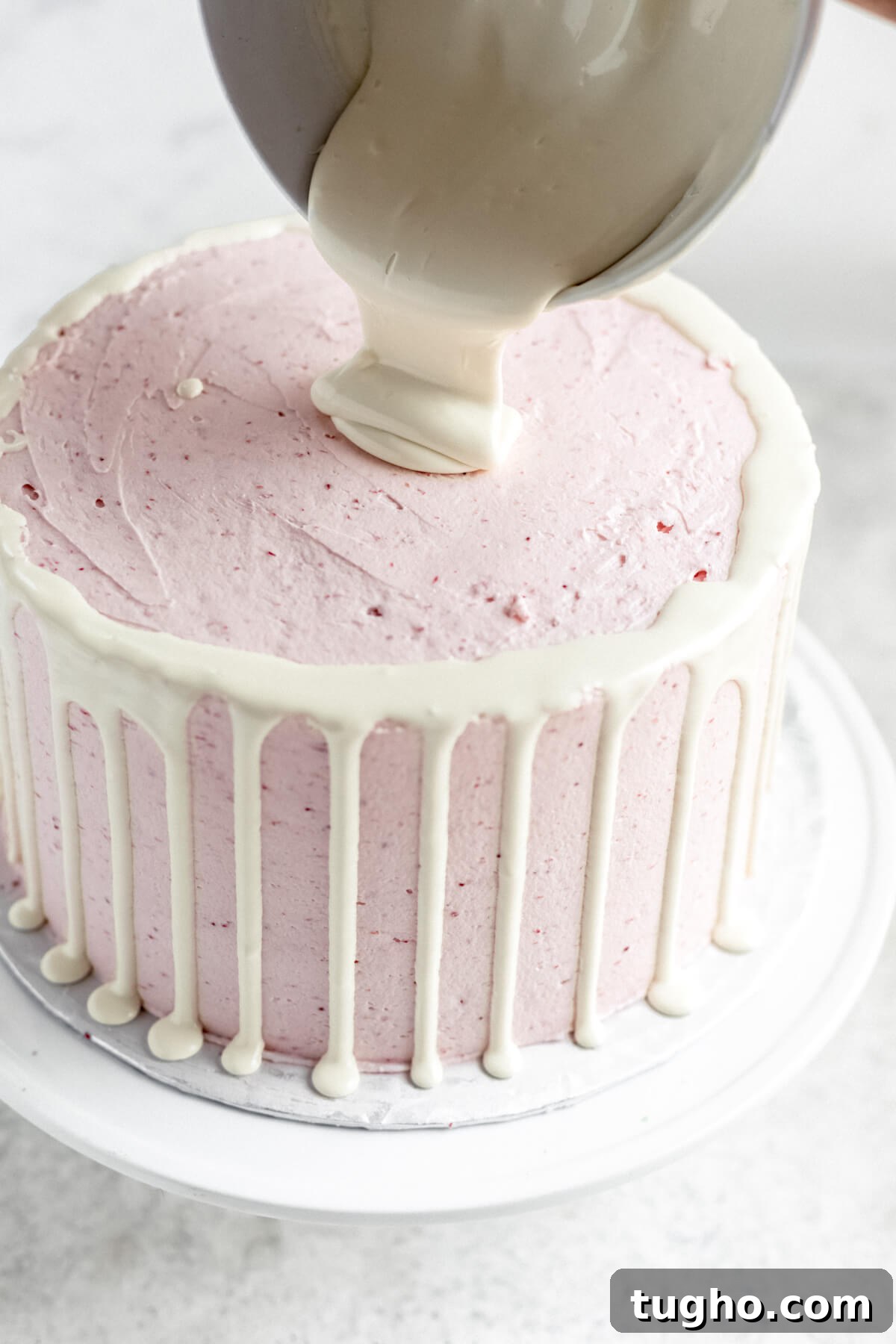 White Chocolate-Covered Strawberry Cake Recipe 9 pouring white chocolate ganache into the centre of cake