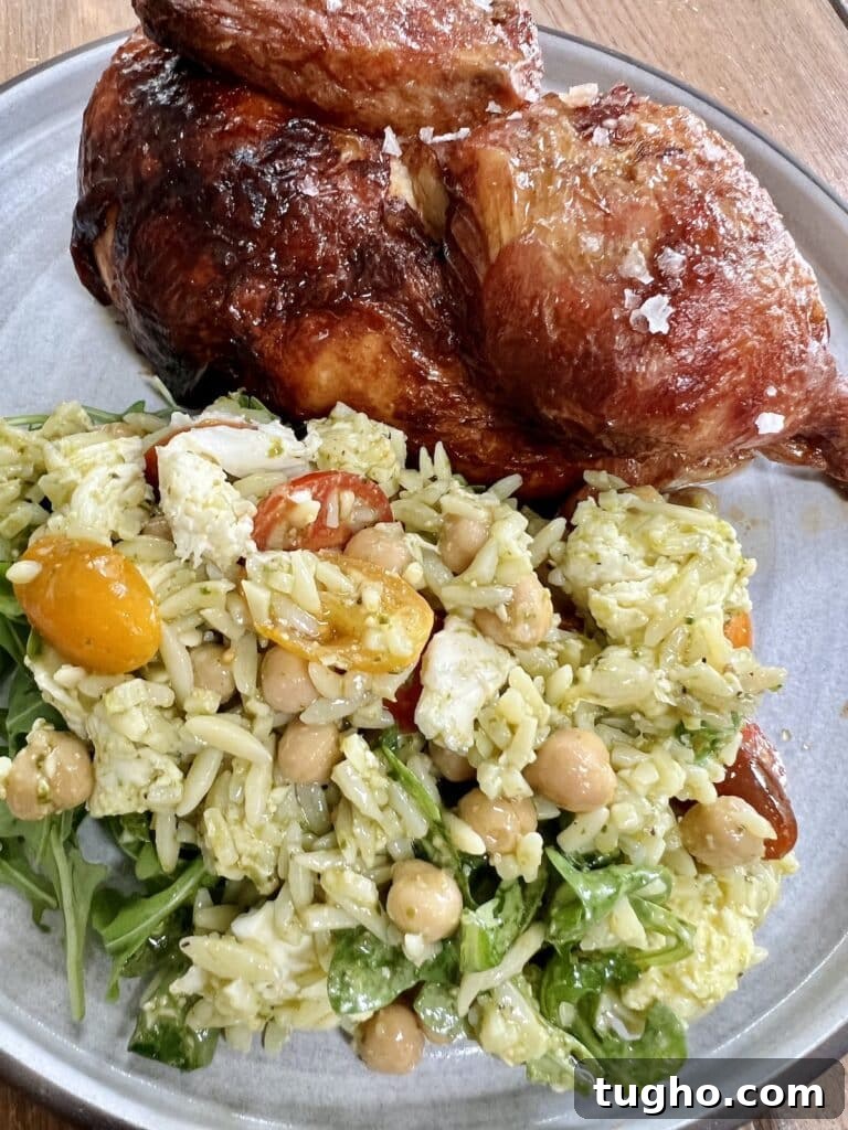 Pesto Orzo Caprese Salad with Cherry Tomatoes and Mozzarella 8 Pesto orzo pasta salad caprese on plate with roasted half chicken.