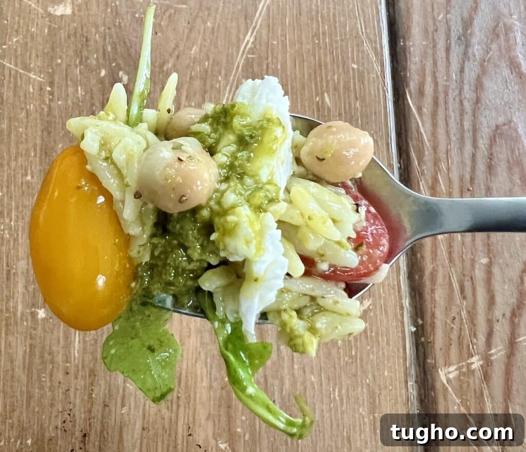 Pesto Orzo Caprese Salad with Cherry Tomatoes and Mozzarella 3 Close up of finished dish on spoon.