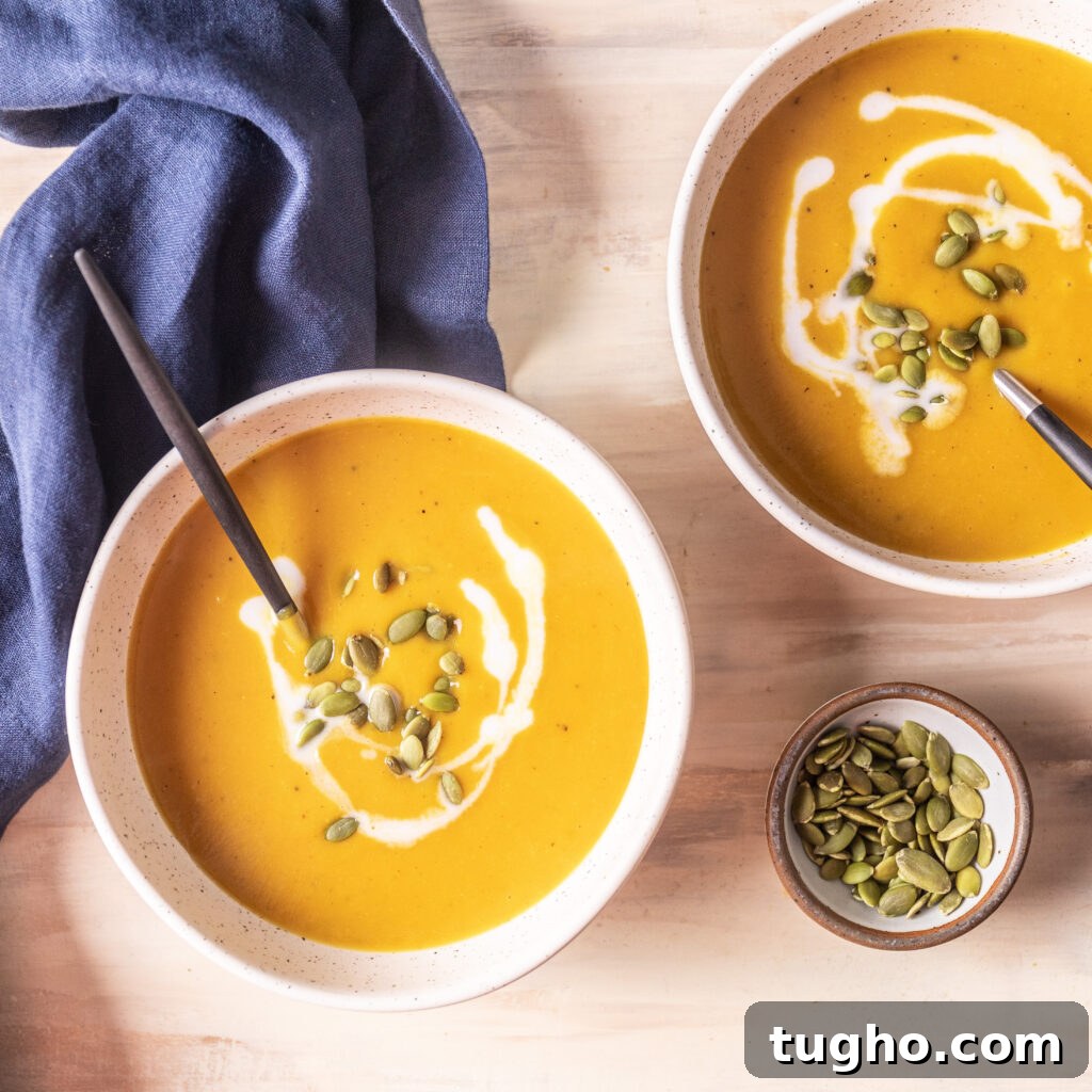 Velvety Roasted Butternut Squash and Carrot Soup Recipe 6 2 bowls of butternut squash and carrot soup topped with pepitas and coconut milk, with a small bowl of pepitas
