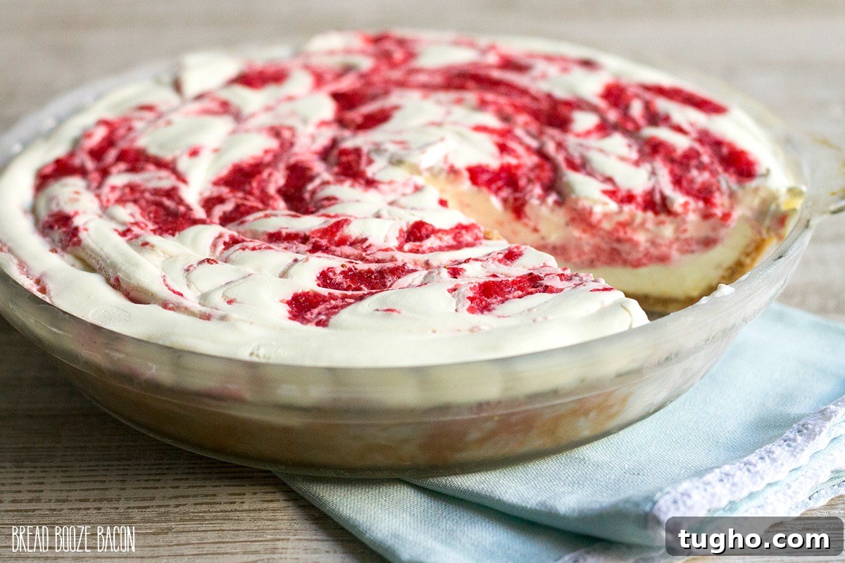 No Bake Strawberry Lemonade Pie just out of the freeze with a slice cut out to see the inside