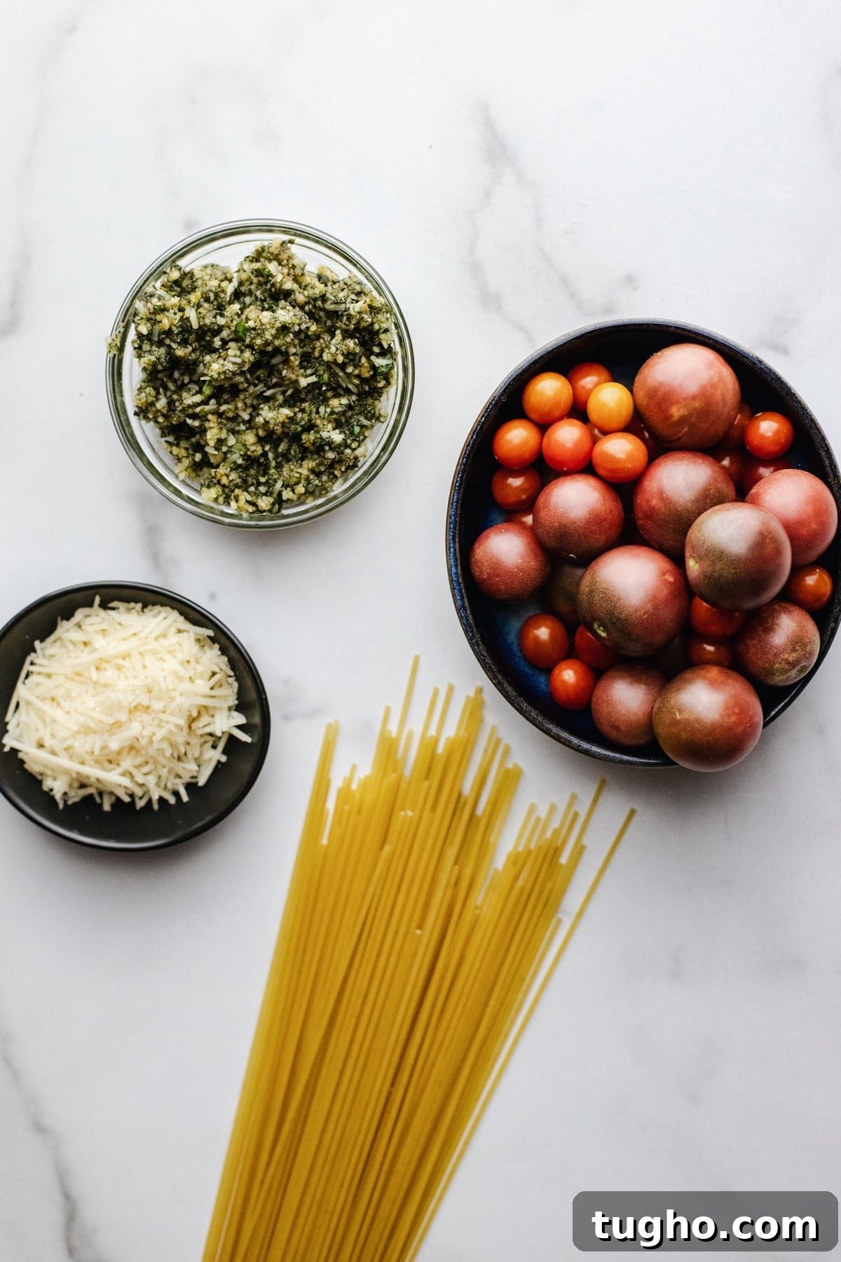 Pesto Spaghetti with Fresh Garden Tomatoes 3 Ingredients for spaghetti pesto arranged on a white counter.