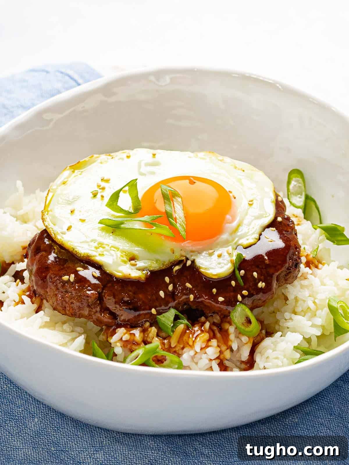Loco Moco Recipe: Hawaiian Burger with Savory Brown Gravy 8 Loco moco made with a juicy burger, savory brown gravy, and a fried egg garnished with green onions.