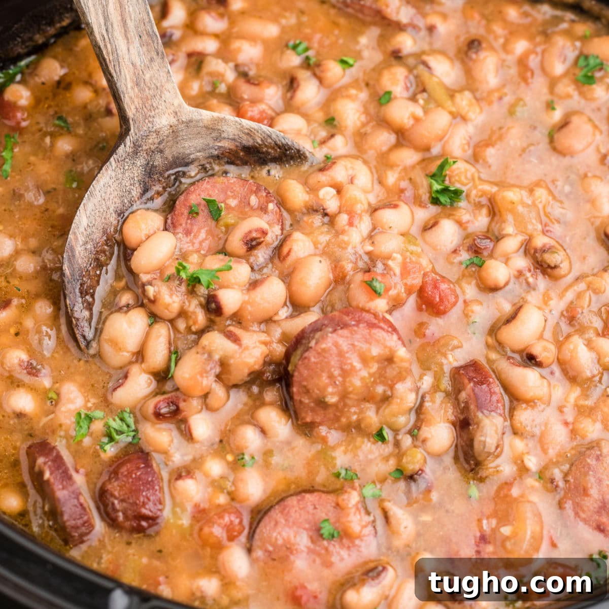 Close up shot cropped square, of a crock pot hoppin john with a spoon diggin in.