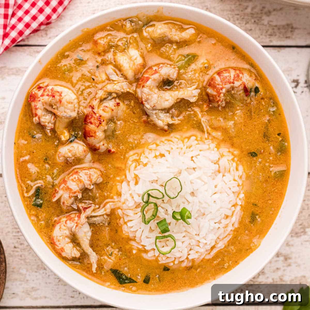 Bowl of crawfish etouffee with rice scoop in the middle.