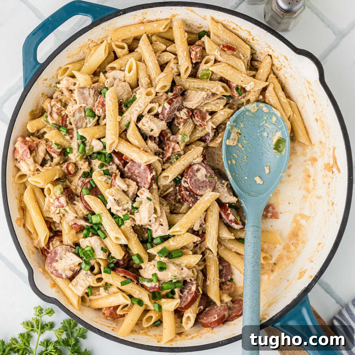 A large skillet filled with Cajun Chicken and Sausage pasta.