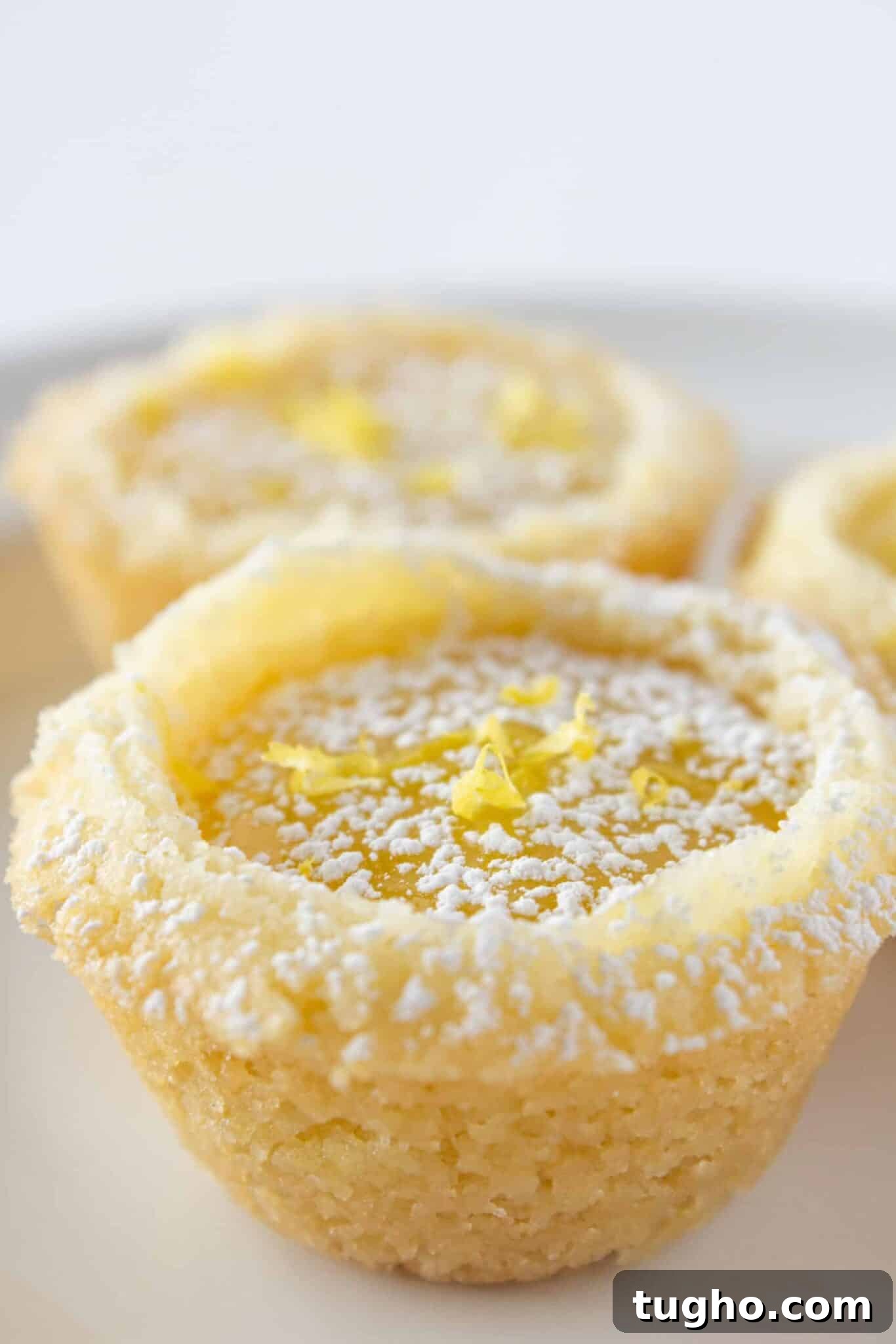 Lemon Bar Cookie Cups Recipe: Zesty Citrus Dessert Cups 5 Lemon Bar Cookie Cups being served on a white tray.
